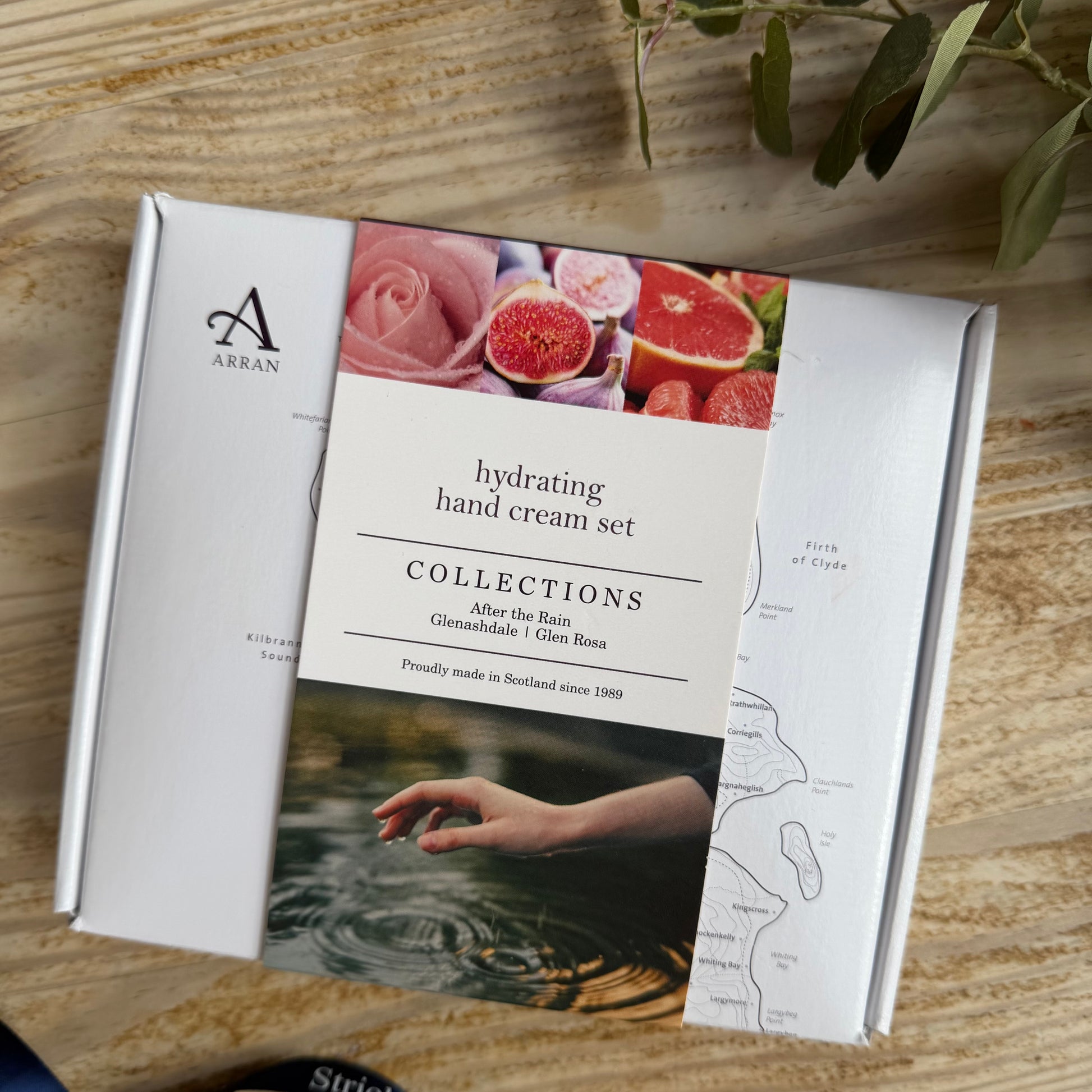 Hand cream set packaging with branding and product images on a wooden surface