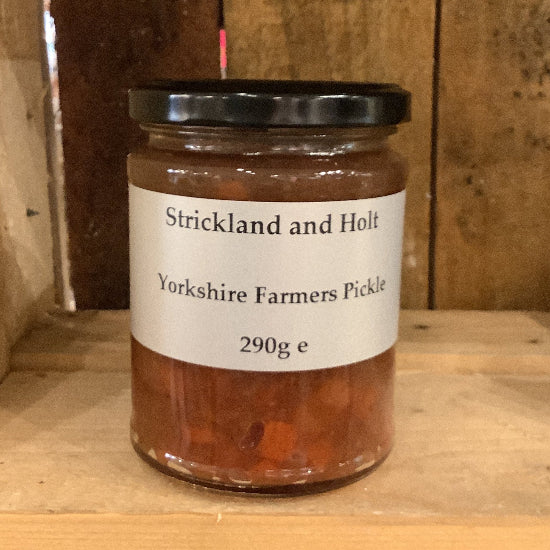 Jar of Yorkshire Farmers' Pickle on a wooden shelf with 'Strickland and Holt' label.