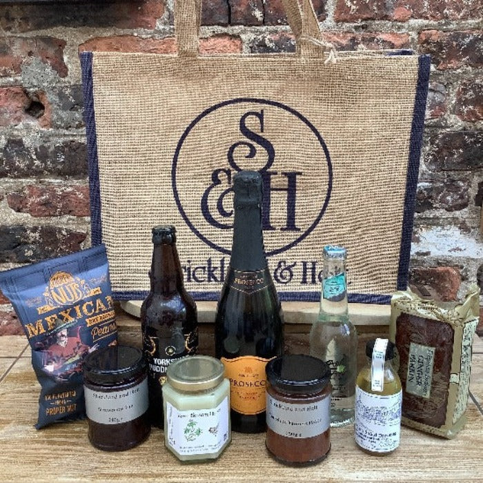 hamper bag with nut, jams, conserves, cake, beer and prosecco